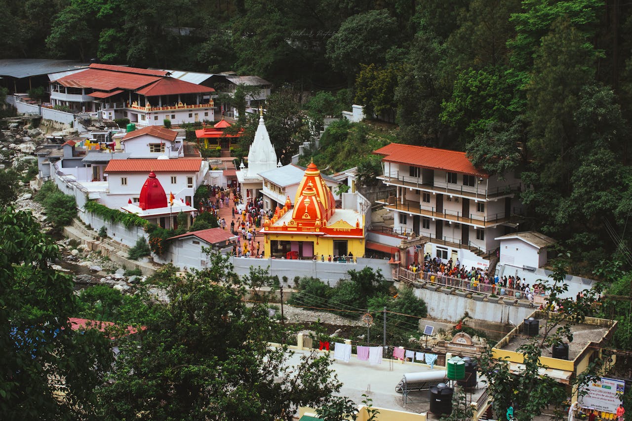 A stunning aerial shot of the iconic Kainchi Dham temple enveloped by lush forests in India.